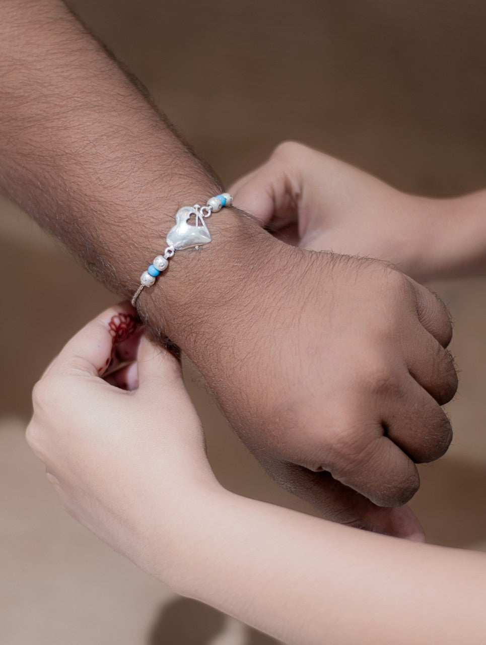 Elegant Silver Heart Rakhi with Blue & Silver Pearls