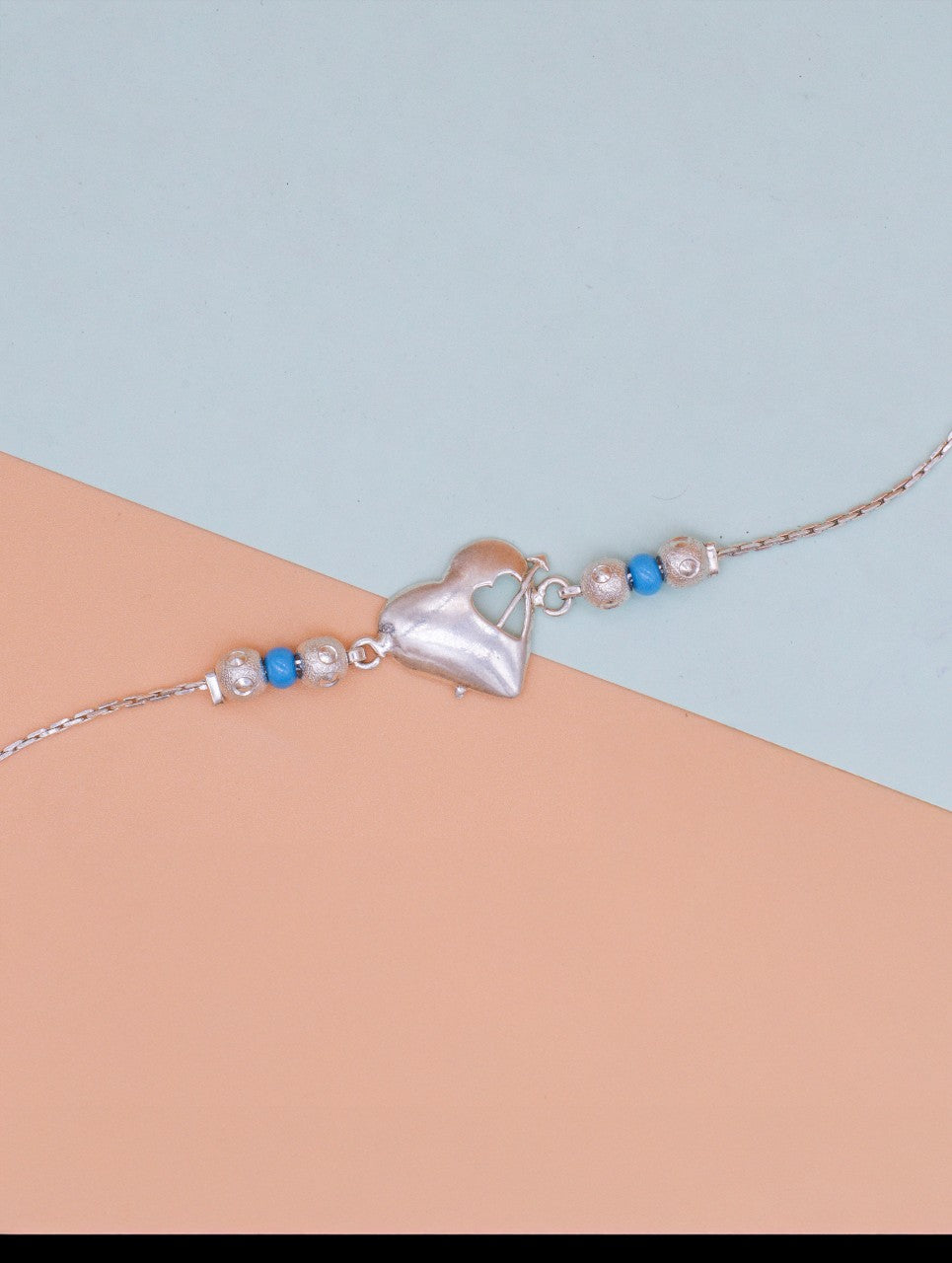Elegant Silver Heart Rakhi with Blue & Silver Pearls