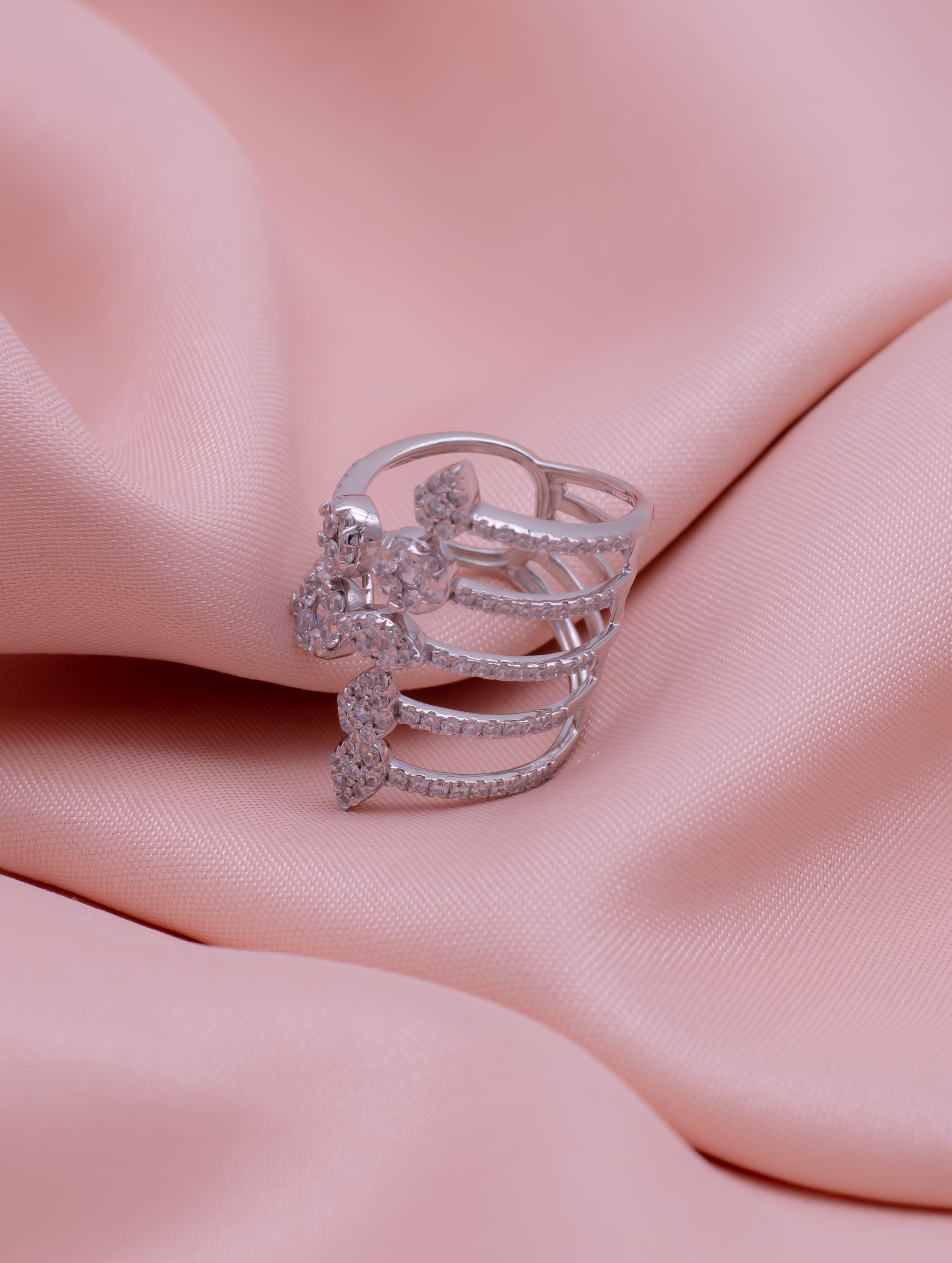 Silver ring with multiple bands on a pink fabric background