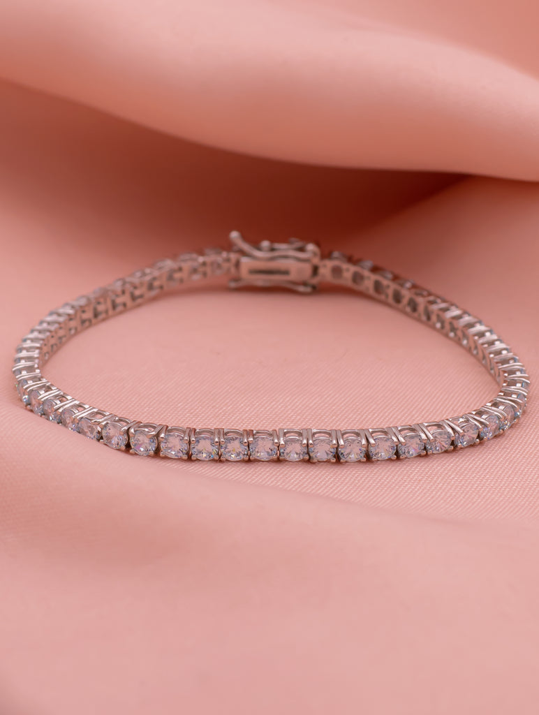 Silver bracelet with pink stones on a pink fabric background