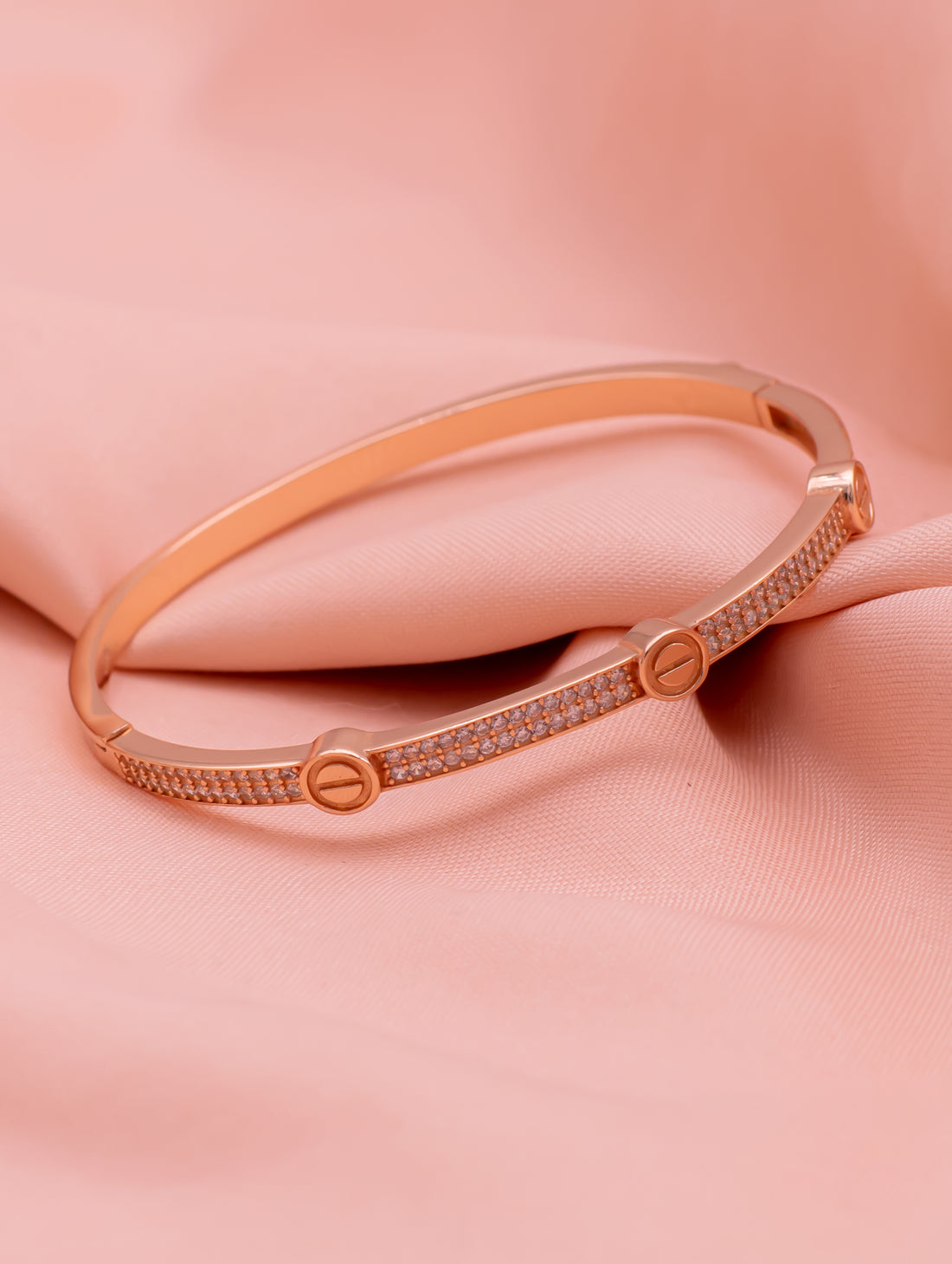 Rose gold bracelet on a soft pink background