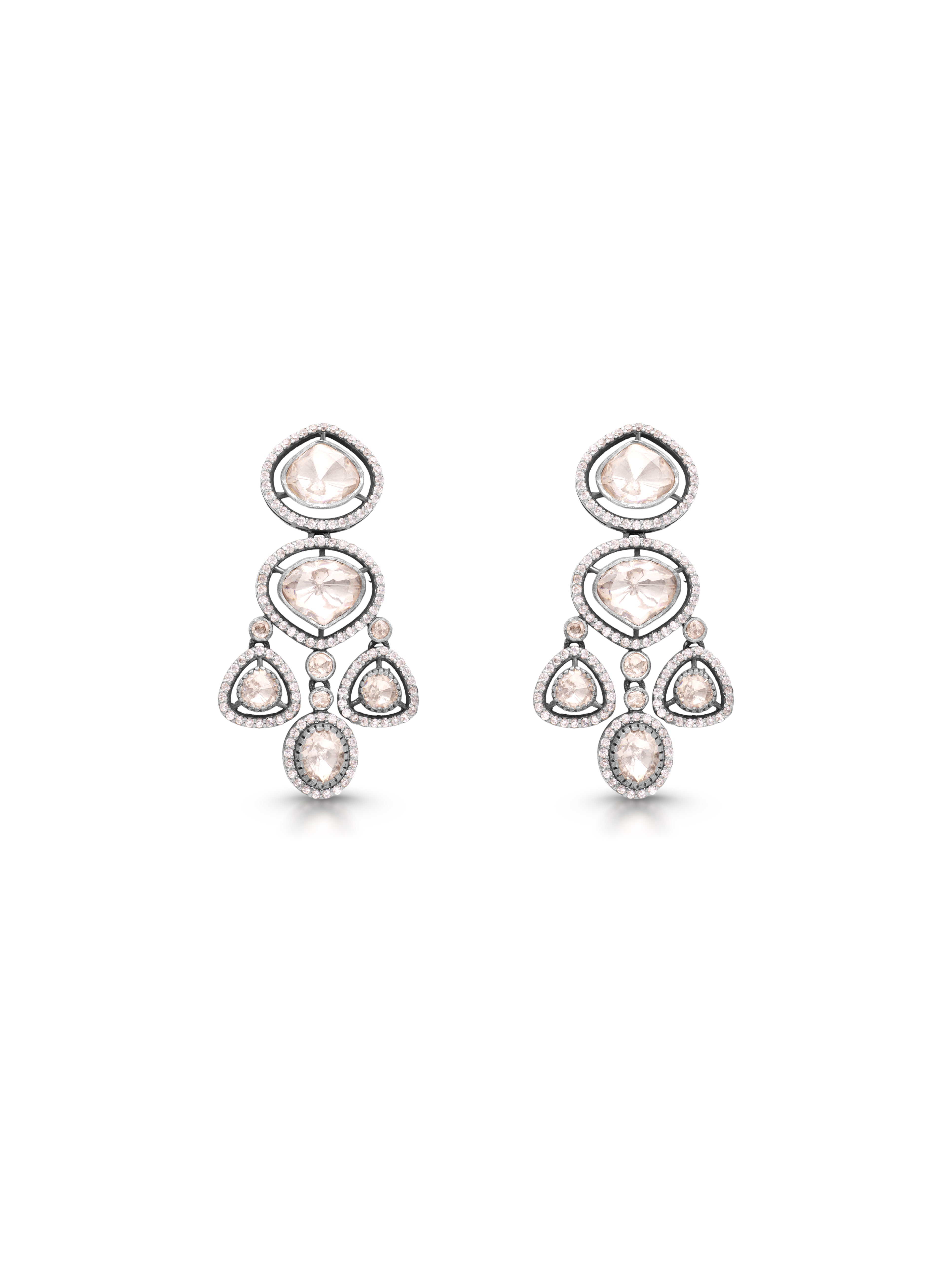 Pair of chandelier earrings with clear and pink gemstones on a white background