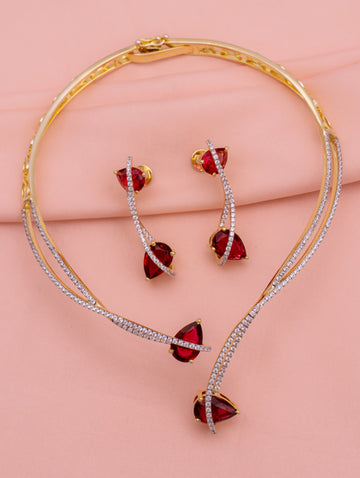 Jewelry set with red gemstones on a pink background